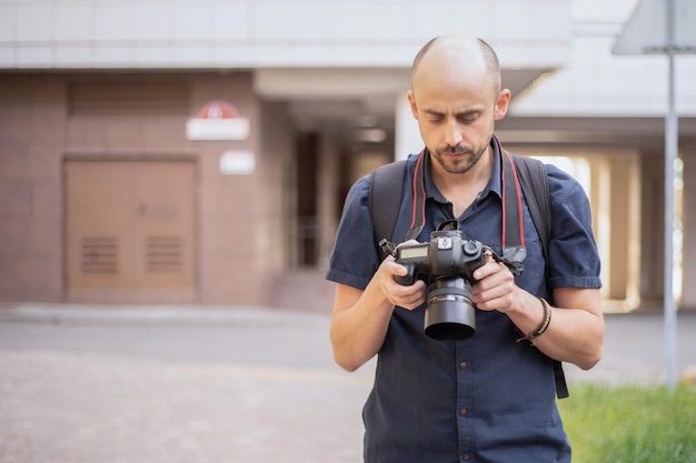 Young man with a camera standing on a city street