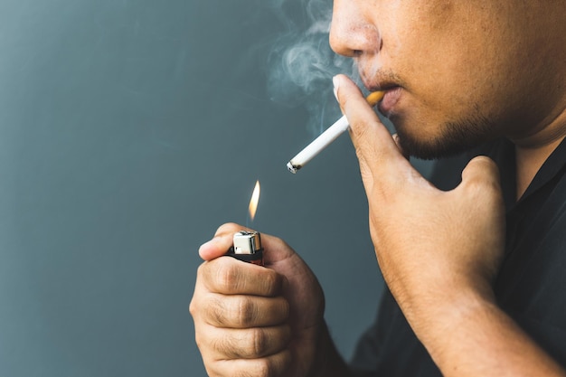 A young man with a cigarette He is going to smoke He lit the cigarette lighter with a lighter. world tobacco day.