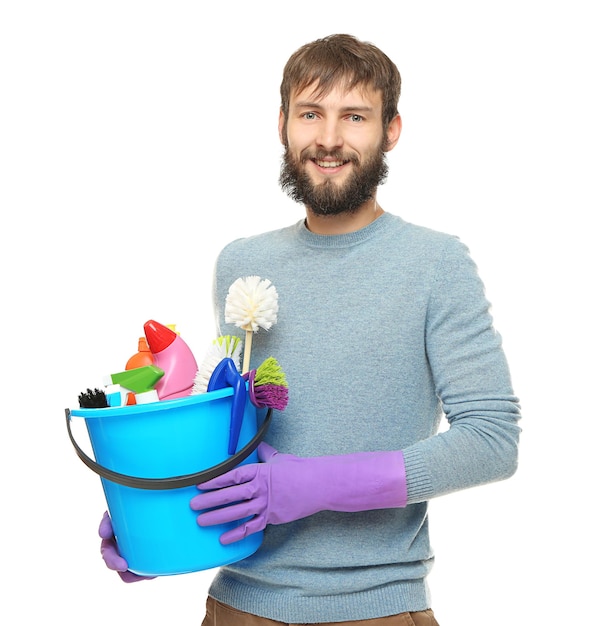 Young man with cleaning supplies on white background