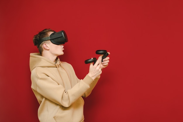 Young man with controller in his hands and VR helmet playing video games