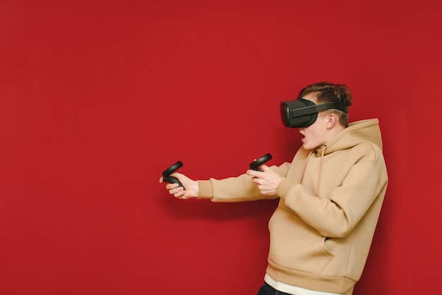 Young man with controller in his hands and VR helmet playing video games