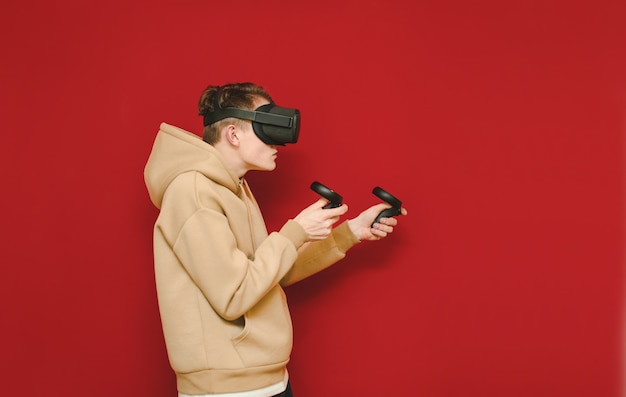 Young man with controller in his hands and VR helmet playing video games