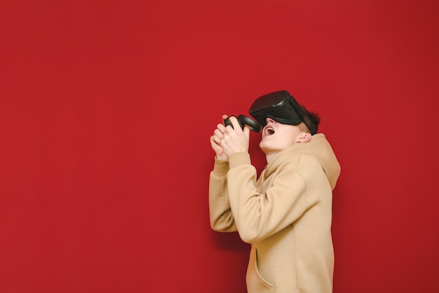 Young man with controller in his hands and VR helmet playing video games