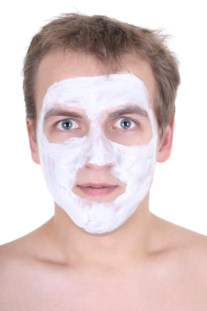 Young man with cosmetic mask on his face over white