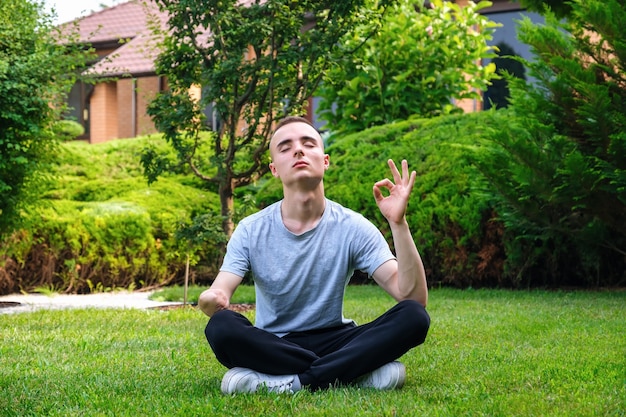 Young man with disability meditating yoga outdoors