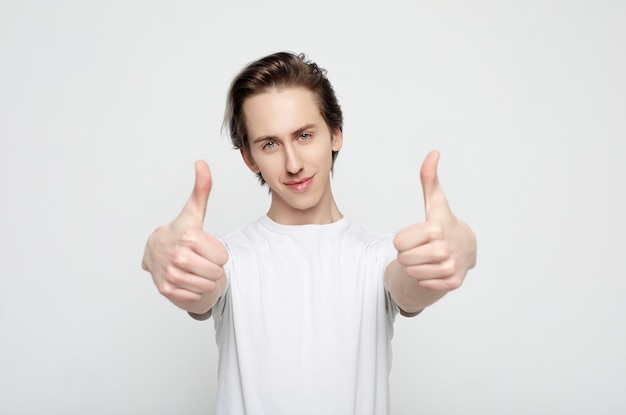 Young man with emotions on his face a grey background