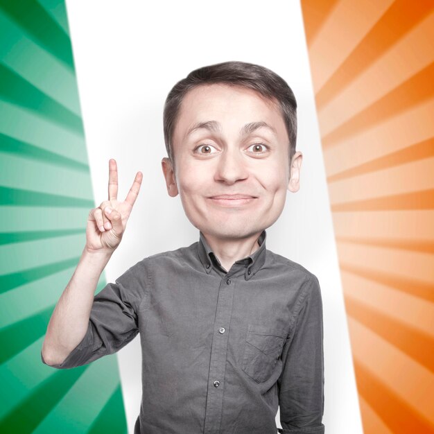 Young man with the fingers in a victory sign on background of the flag of Ireland