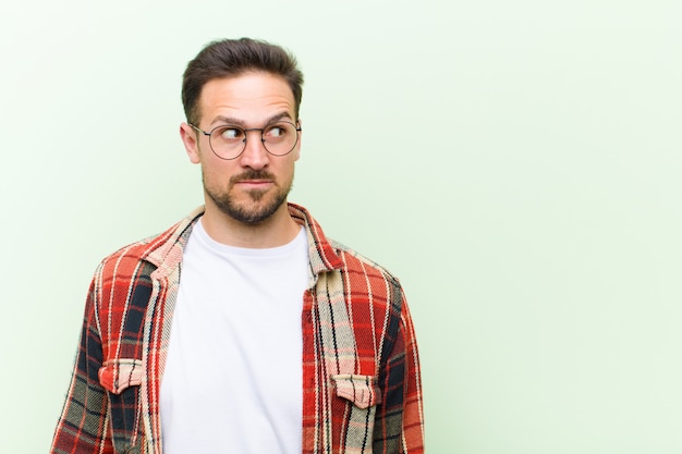 a young man with glasses posing while wondering