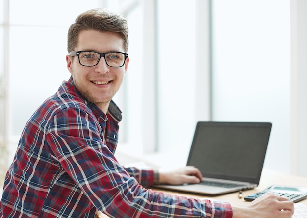 Young man with glasses working on his notebook getting the business out of the way