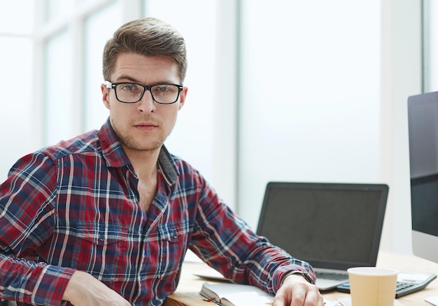 Young man with glasses working on his notebook getting the business out of the way