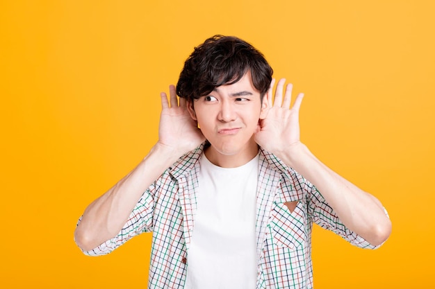 Photo young man with hand over ear listening and hearing