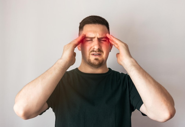 Photo young man with headache holding his head with both hands