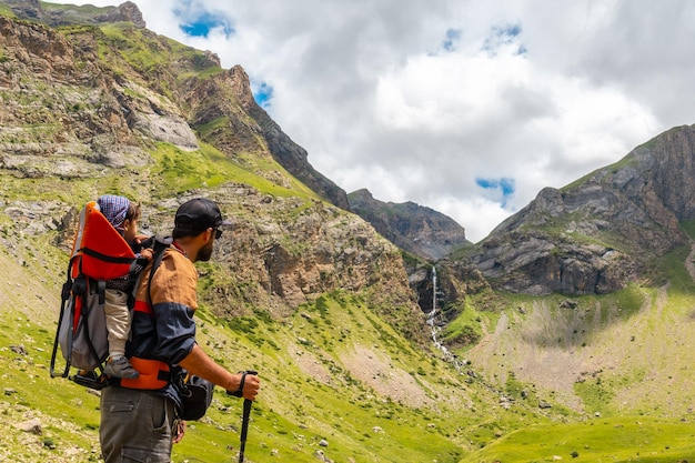 A young man with his son at the Salto de Tendenera Waterfall in the Ripera Valley Panticosa Pyrenees