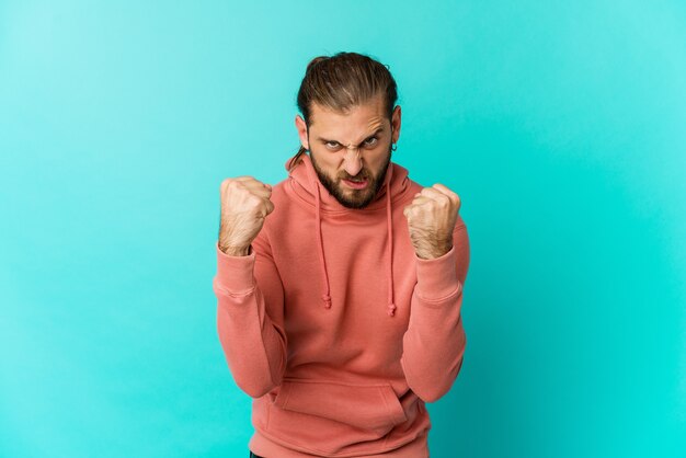 Young man with long hair look upset screaming with tense hands.