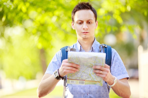 Young man with a map outdoors