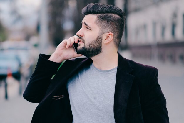 Young man with mobile phone in the street