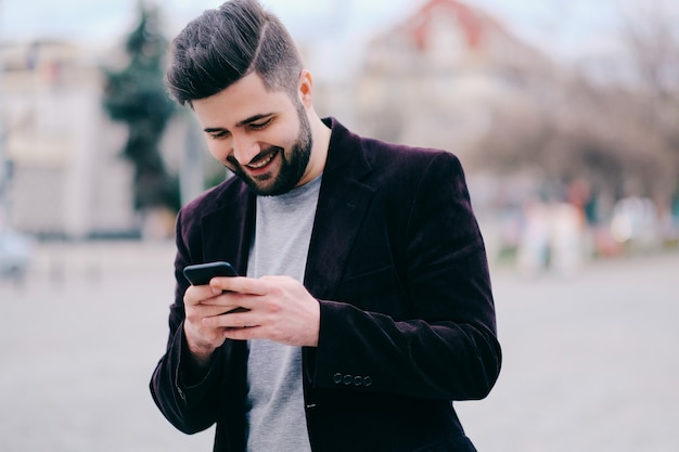 Young man with mobile phone in the street