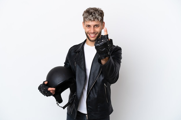 Young man with a motorcycle helmet isolated on white background doing coming gesture