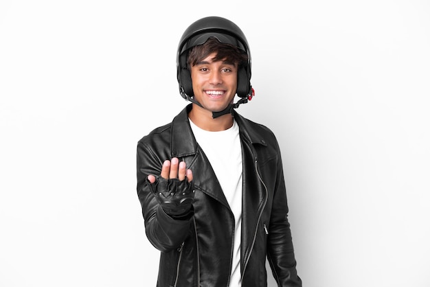 Young man with a motorcycle helmet isolated on white background inviting to come with hand Happy that you came