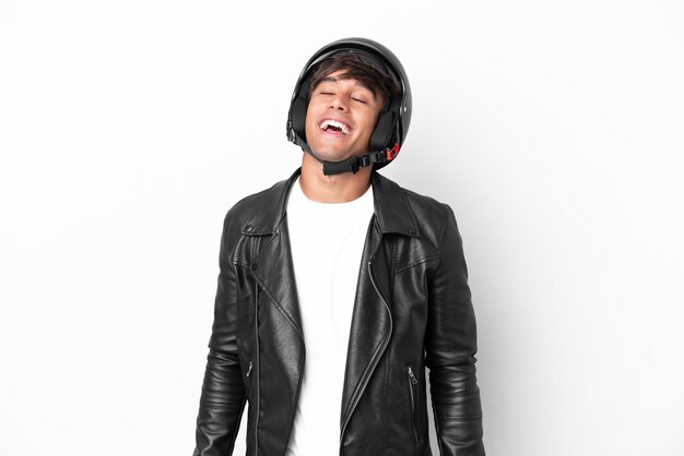 Young man with a motorcycle helmet isolated on white background laughing