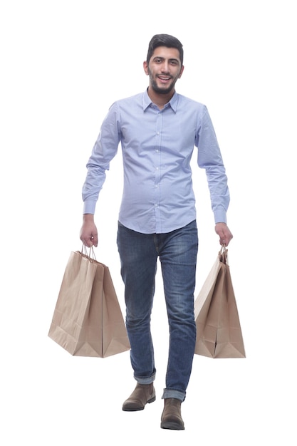 Young man with shopping bags striding forward