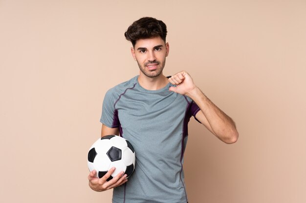 Young man with soccer ball and proud of himself