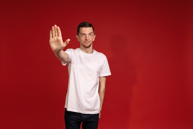 A young man with Treacher Syndrome shows a stop gesture