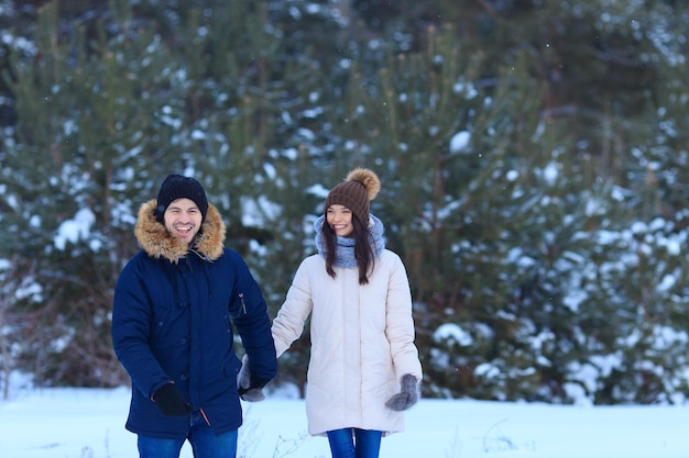 Young man and woman holds hands in forest