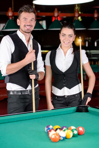 Young man and woman playing professional billiards.