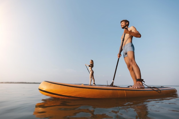 Young man and a woman on a walk on sap boards