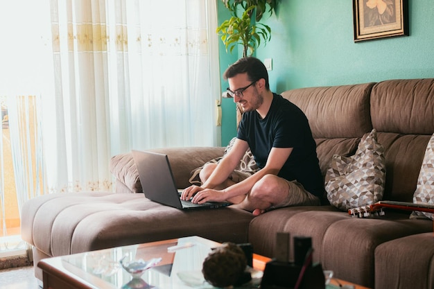 Young man works from home with his laptop