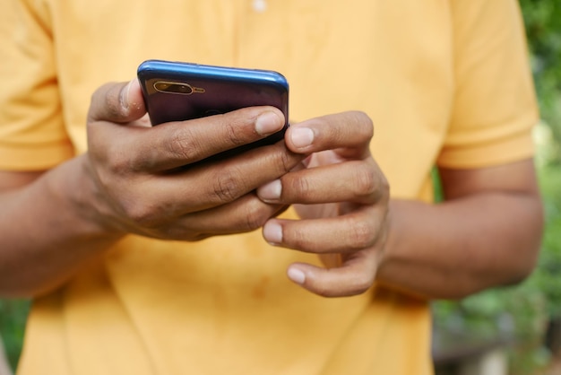 Young man in yellow shirt using smart phone