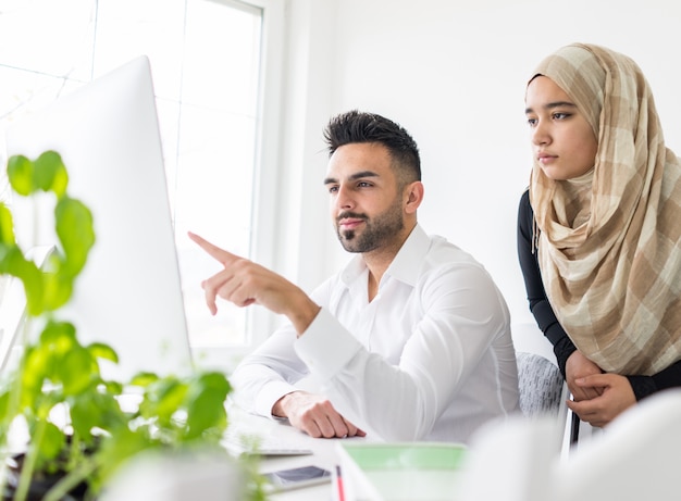 Young mand and woman working in office on computer