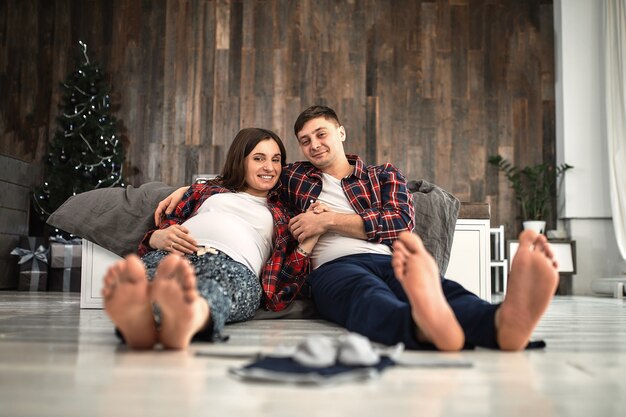 A young married couple awaiting a baby. Beautiful couple lying in the bedroom make plans for the birth of a baby. First child, postpartum, young family.