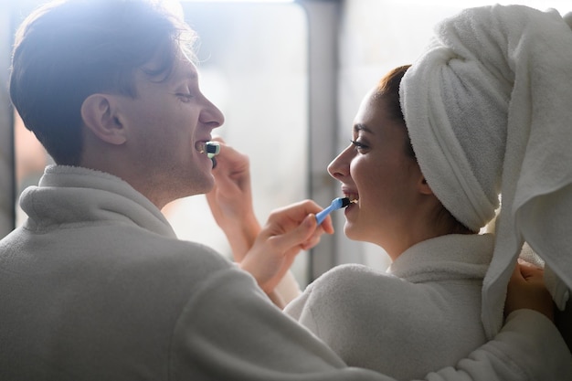 A young married couple brushing their teeth together dental hygiene