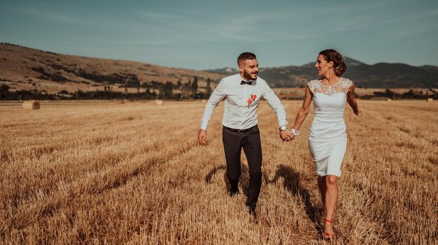 a young married couple in a large field enjoys the sunset. Selective focus. High quality photo