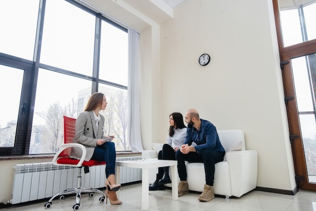 A young married couple of men and women talk to a psychologist at a therapy session. Psychology.