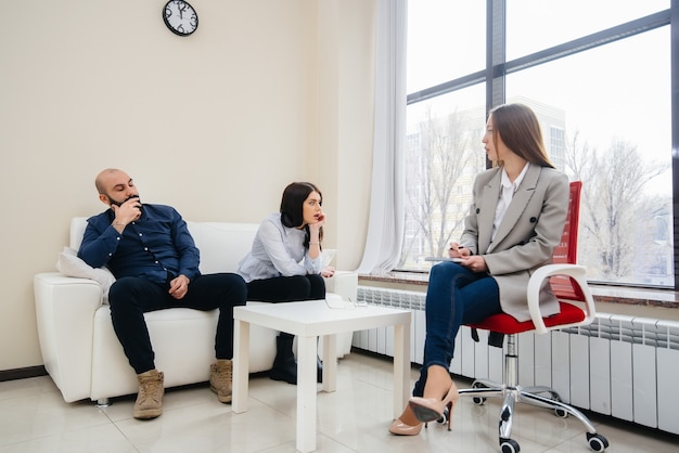 A young married couple of men and women talk to a psychologist at a therapy session