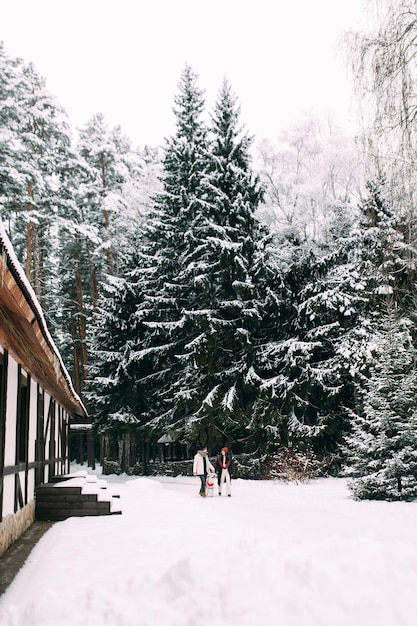 Young married couple with a dog walking in a snowy recreation center