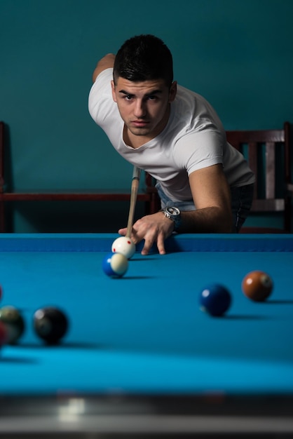 Young Men Lining To Hit Ball On Pool Table