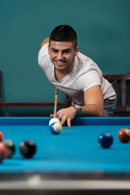 Young Men Lining To Hit Ball On Pool Table