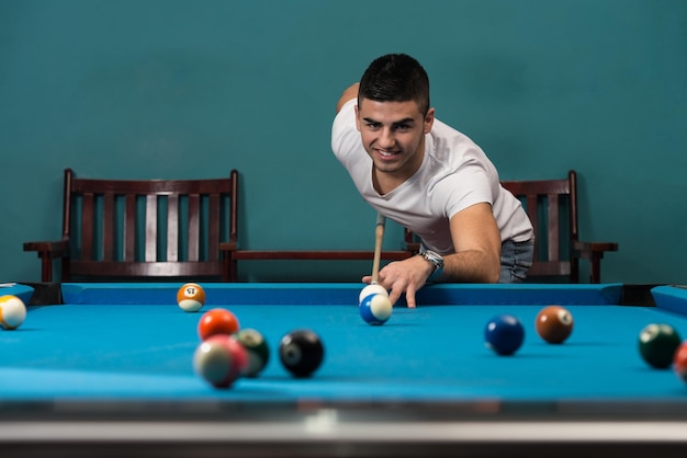 Young Men Lining To Hit Ball On Pool Table