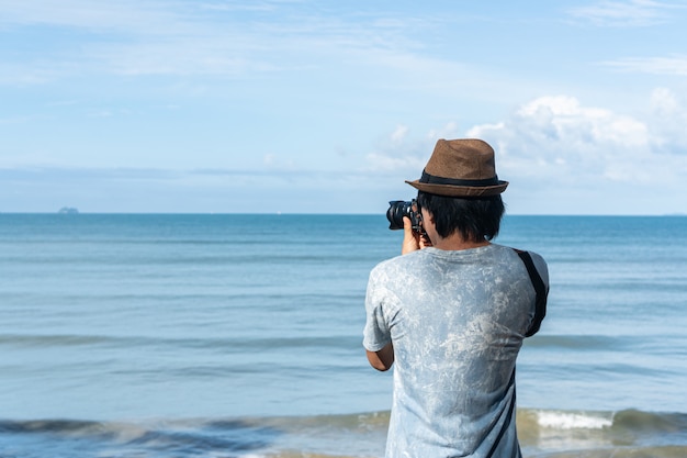 Young men take a photo at the tropical beach.