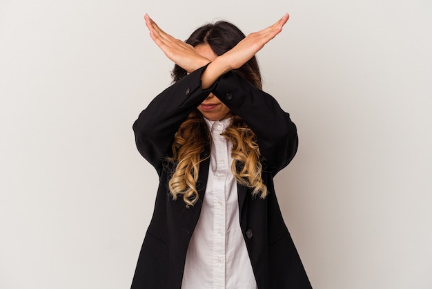 Young mexican business woman isolated on white background keeping two arms crossed, denial concept.