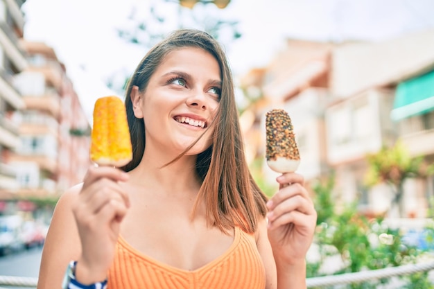 Young middle east girl smiling happy eating ice cream walking at the city.