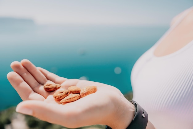 Young milky almond nuts in womans hand a young caucasian woman eating fresh almond after morning