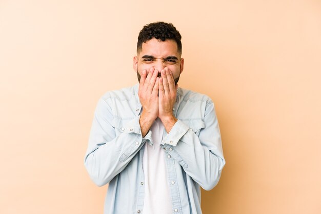 Young mixed race arabic man isolated laughing about something, covering mouth with hands.