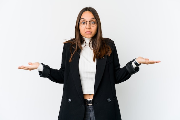 Young mixed race business woman isolated on white doubting and shrugging shoulders in questioning gesture.