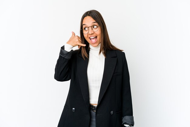 Photo young mixed race business woman isolated on white showing a mobile phone call gesture with fingers.