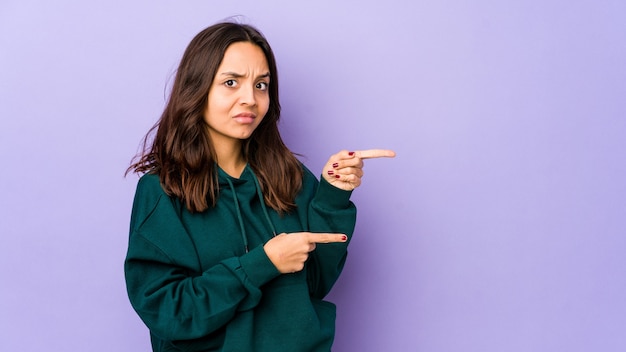 Young mixed race hispanic woman isolated shocked pointing with index fingers to a copy space.